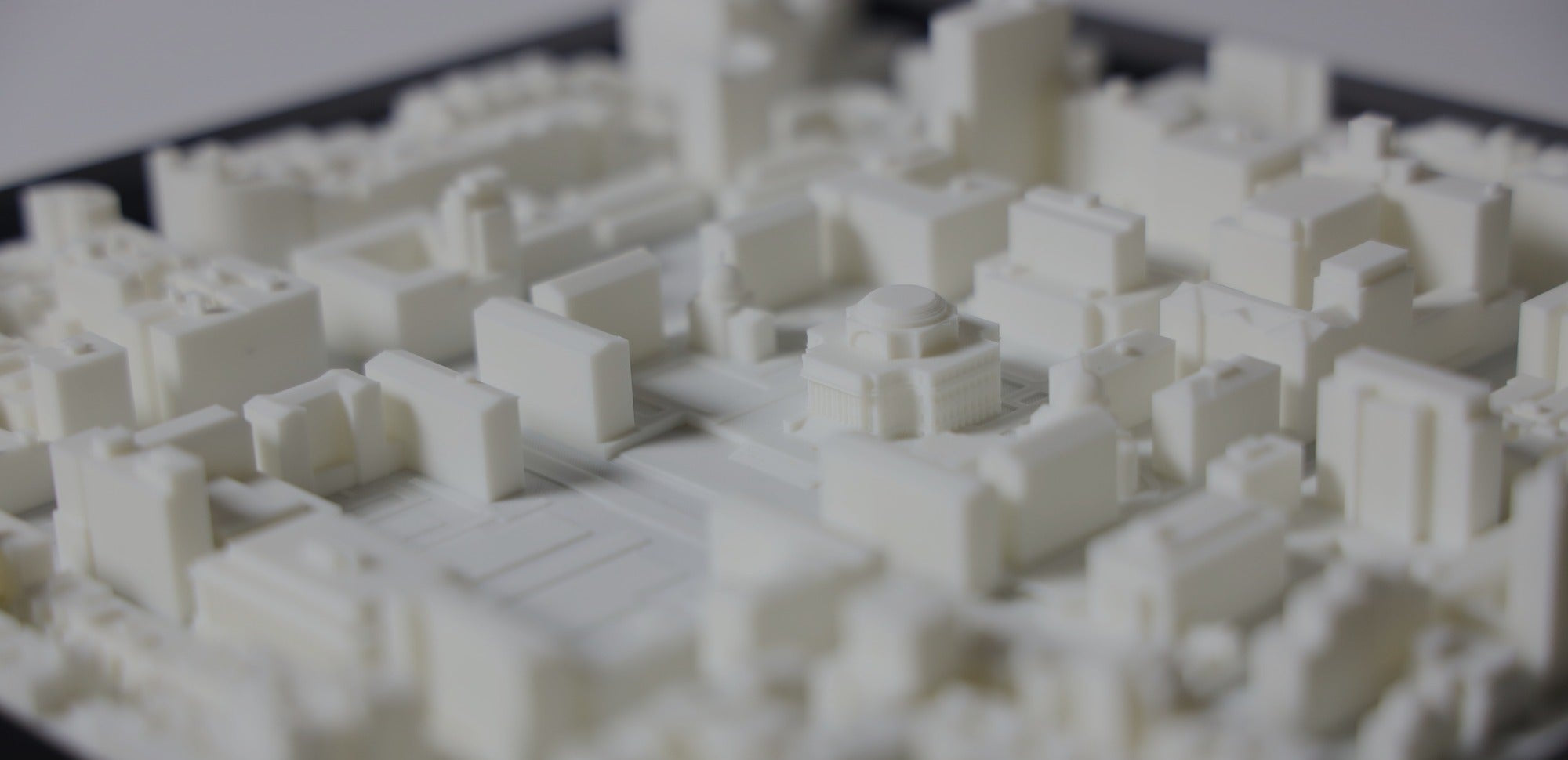 Close-up of a 3D-printed model of a cityscape on a black tray.